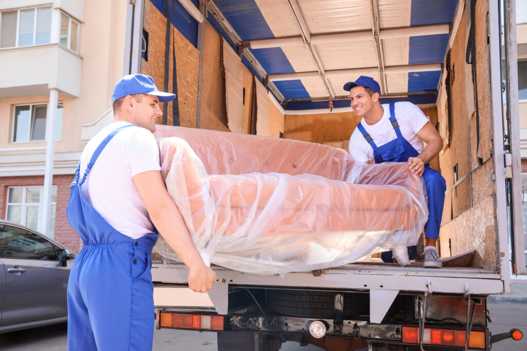 movers carrying covered furniture